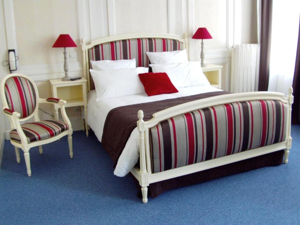 Chambre du Grand Hotel avec lit double et fauteuil de style Louis XVI